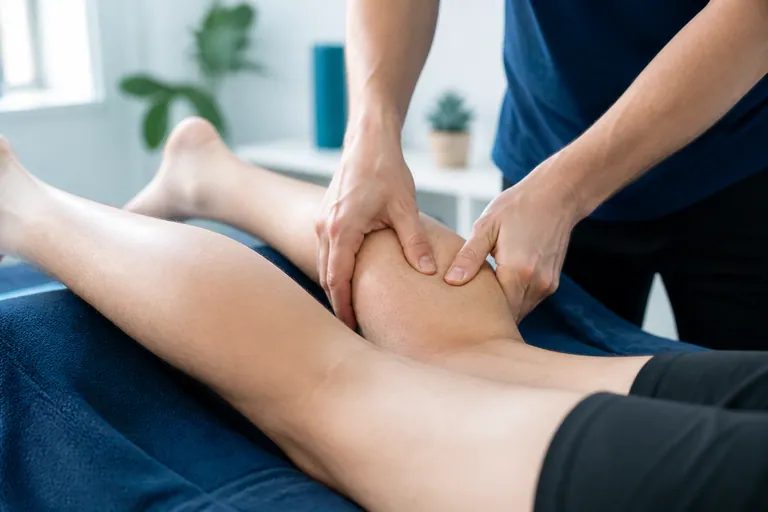 Sports massage focused on the lower leg in a clean treatment room
