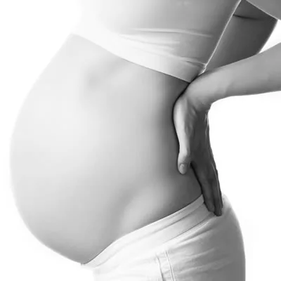 Pregnant person supporting their lower back